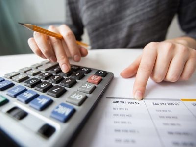 Closeup of Accountant Hands Counting on Calculator