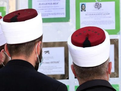 epa09105045 Bosnian priests read a funeral schedule on a bulletin board, amid the ongoing COVID-19 coronavirus pandemic at the Vlakovo Cemetery in Sarajevo, Bosnia and Herzegovina, 29 March 2021. Bosnian authorities have introduced restrictive locking measures, including night curfews and restaurant closures, following an increase in coronavirus infection in the capital.  EPA-EFE/FEHIM DEMIR